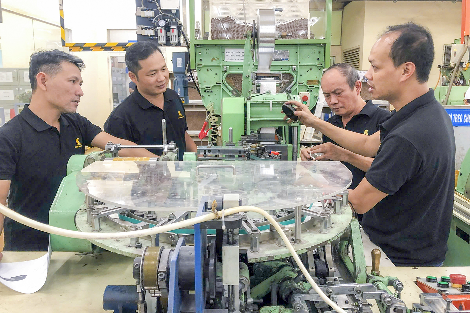 Ông Trương Minh Tiến (bìa trái) cùng đồng nghiệp tại Nhà máy Thuốc lá Khatoco Khánh Hòa thảo luận các giải pháp hợp lý hóa sản xuất.
