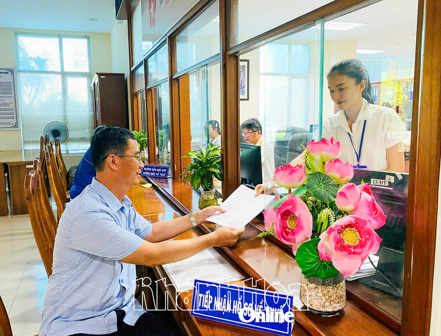 Cán bộ cơ quan thuế hỗ trợ thủ tục cho người dân.