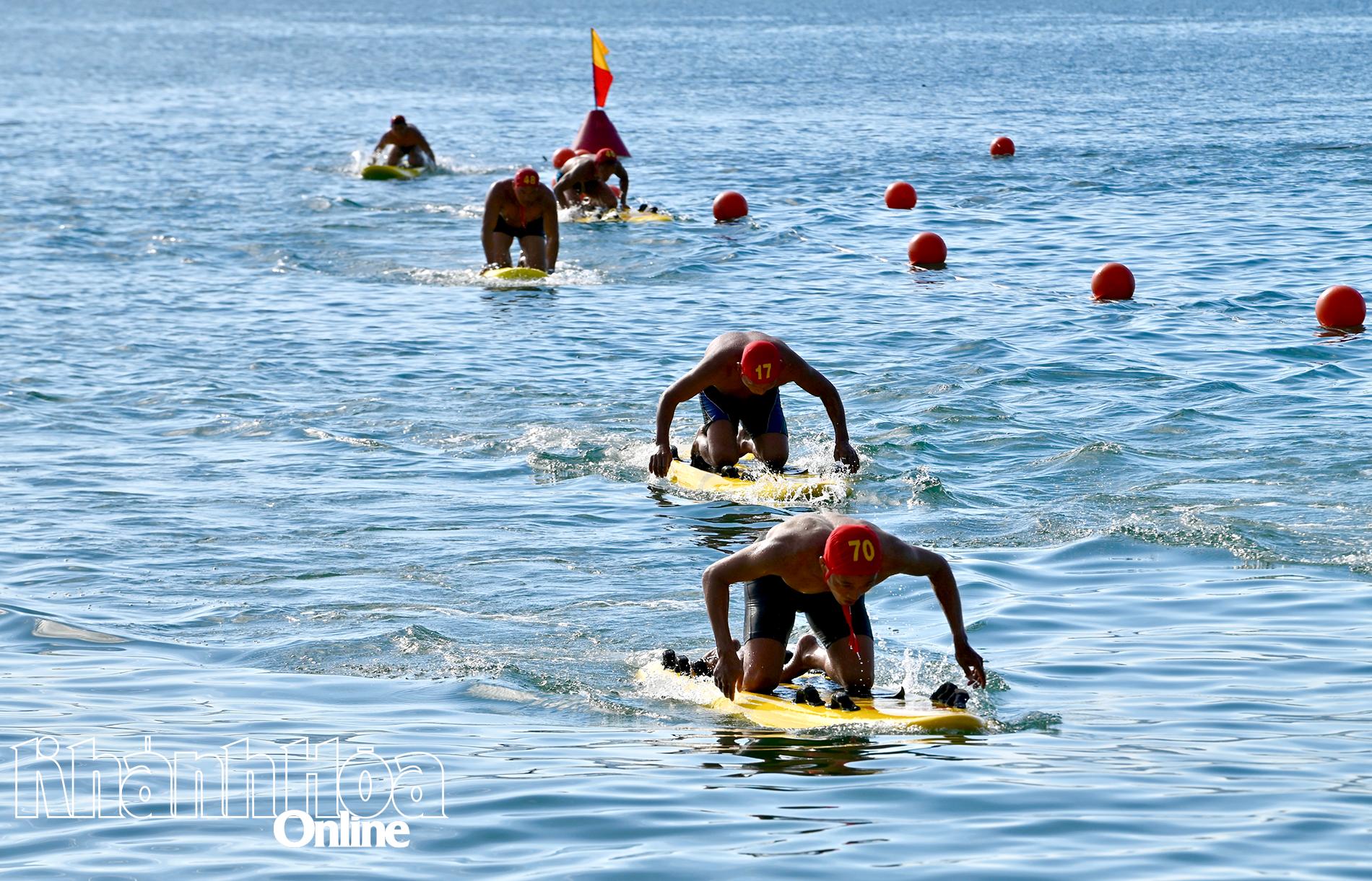 Các vận động viên bơi ván tiếp sức cạnh tranh nơi vạch đích.