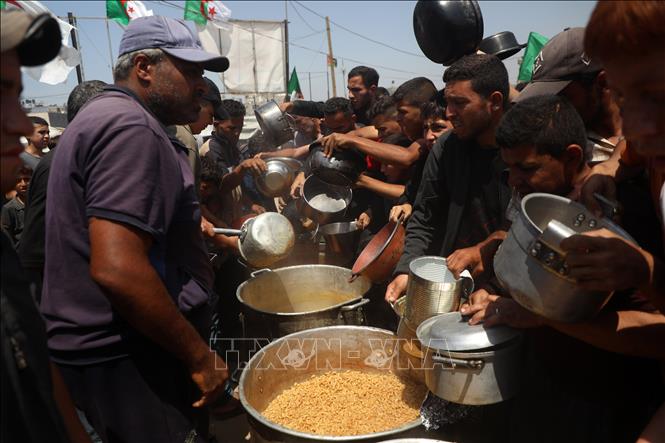 Người dân Palestine nhận thức ăn cứu trợ tại thành phố Gaza ngày 9/5/2025. Ảnh: THX/TTXVN