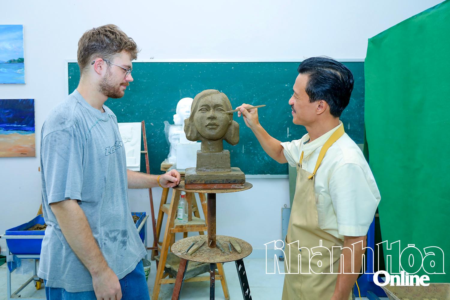 Giảng viên Trường Đại học Khánh Hòa hướng dẫn sinh viên Paul Laurant tìm hiểu về kỹ thuật điêu khắc.