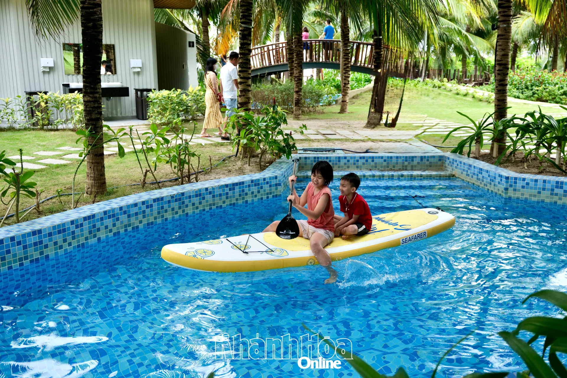 Du khách nhí vui chơi tại hồ bơi trong khuôn viên Arena Resort Cam Ranh, một trong những điểm lưu trú thu hút nhiều gia đình trong mùa du lịch hè tại Bãi Dài.