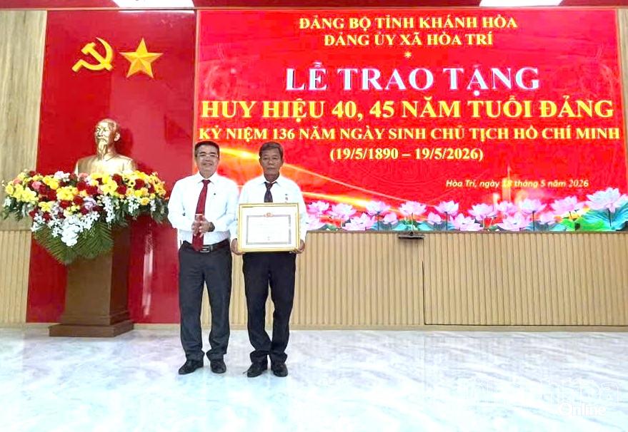 Phó Bí thư Thường trực Đảng ủy xã Hòa Trí Phạm Ngọc Minh trao Huy hiệu Đảng cho đảng viên Huỳnh Văn Lanh