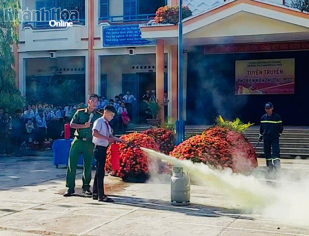Các em học sinh được thực hành sử dụng bình chữa cháy xách tay để dập lửa.