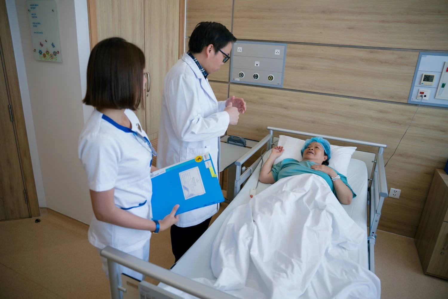 Bác sĩ đi thăm giường bệnh một bệnh nhân vừa trải qua ca phẫu thuật thay khớp gối có sự hỗ trợ của robot tại Vinmec Nha Trang.