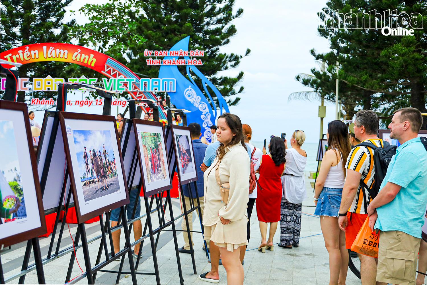 Du khách nước ngoài tham quan một triển lãm nhiếp ảnh được tổ chức trên địa bàn phường Nha Trang.