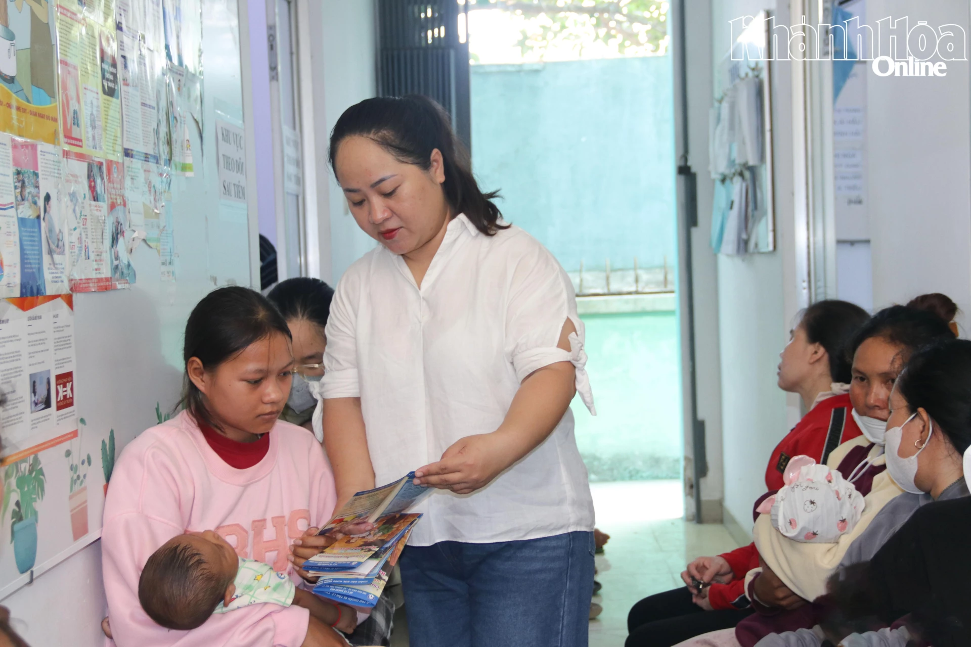 Nhân viên phụ trách công tác dân số Trạm Y tế phường phát tờ rơi tuyên truyền cho người dân.