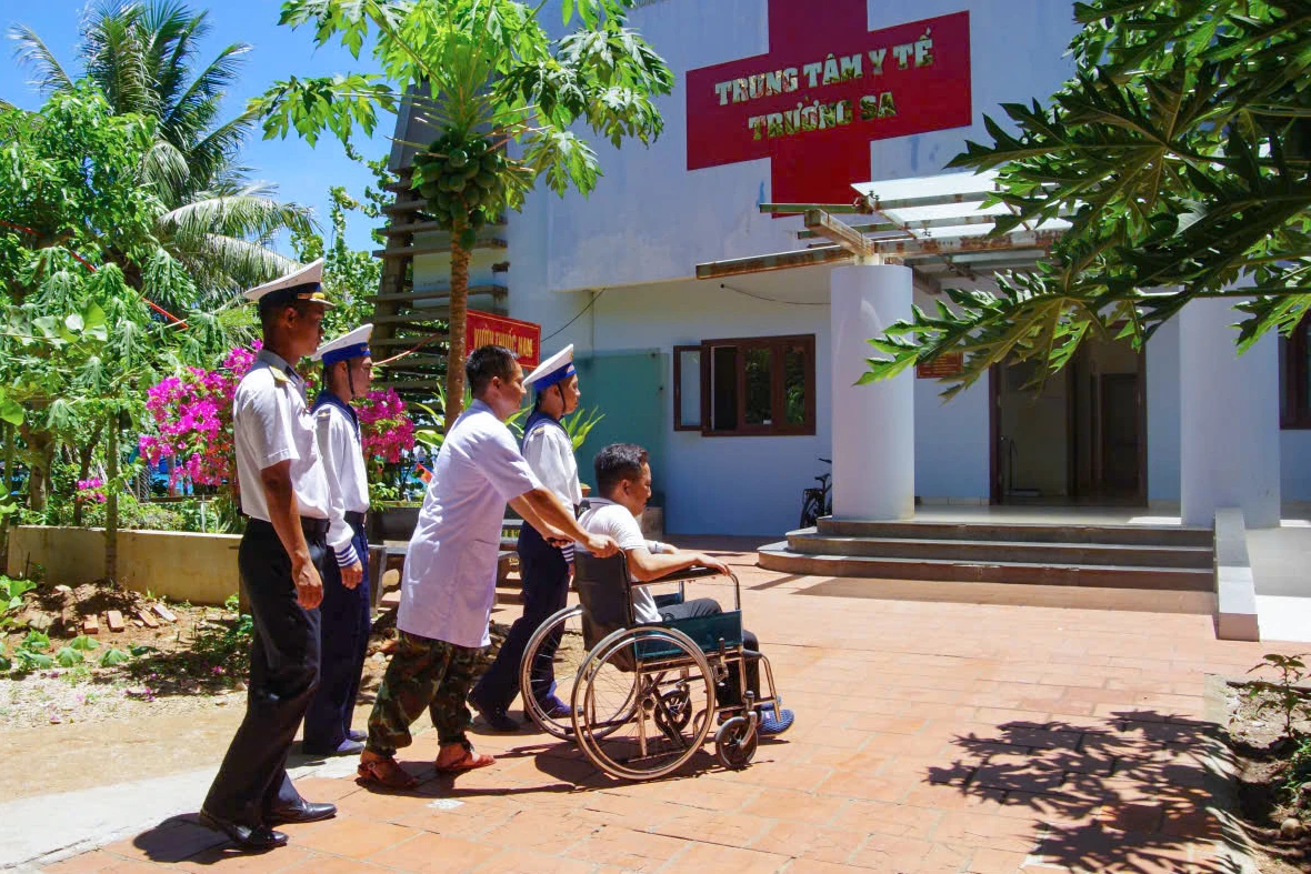 Cán bộ, chiến sĩ đưa ngư dân vào bệnh xá đảo.