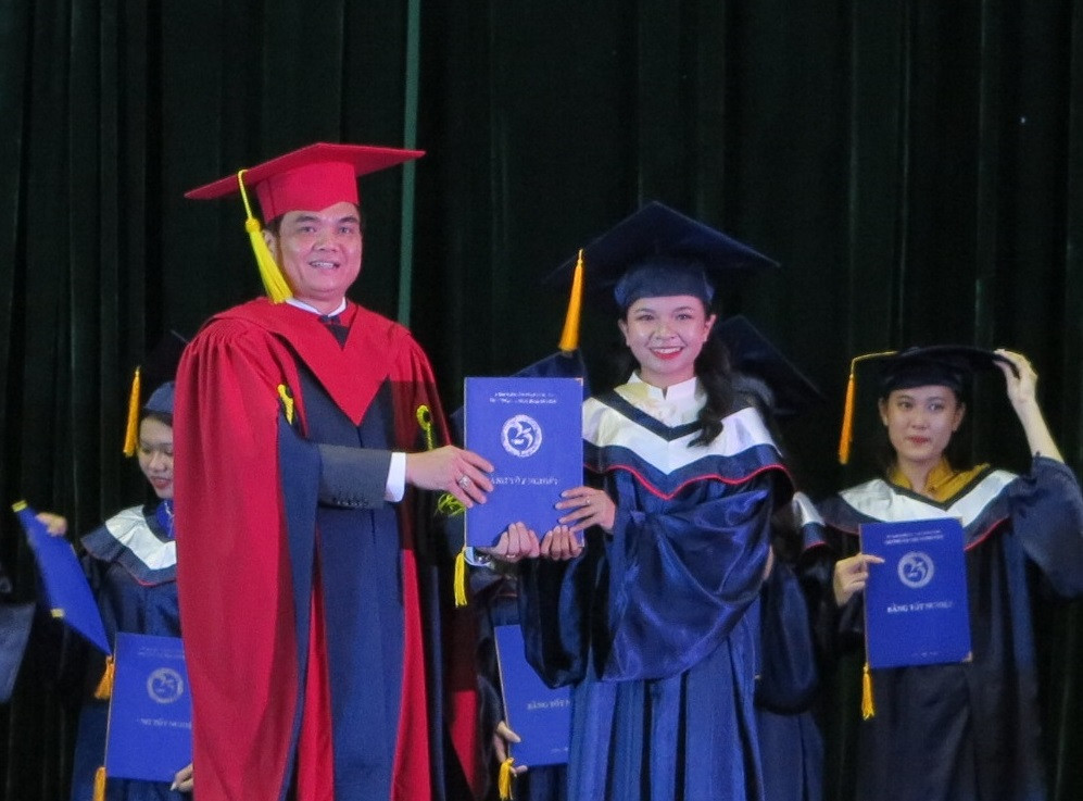 Hiệu trưởng nhà trường trao bằng tốt nghiệp cho sinh viên. 