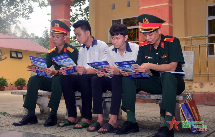 Học viên Trường Sĩ quan Chính trị và cán bộ Ban CHQS huyện Trấn Yên (Yên Bái) tư vấn thông tin về nhà trường Quân đội đến học sinh Trường THPT Lê Quý Đôn (Yên Bái).