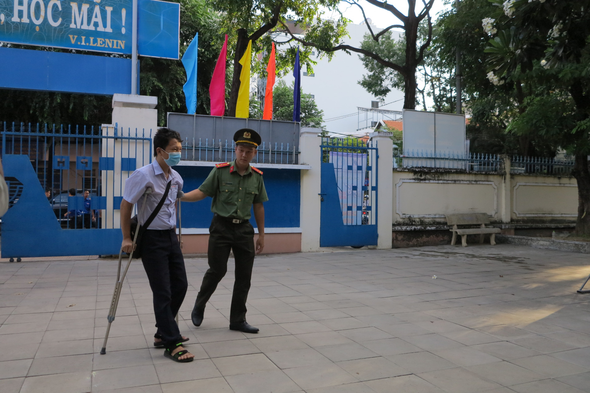 Một thí sinh bị tai nạn gãy chân trước ngày thi được cán bộ công an hỗ trợ đưa vào phòng thi. 