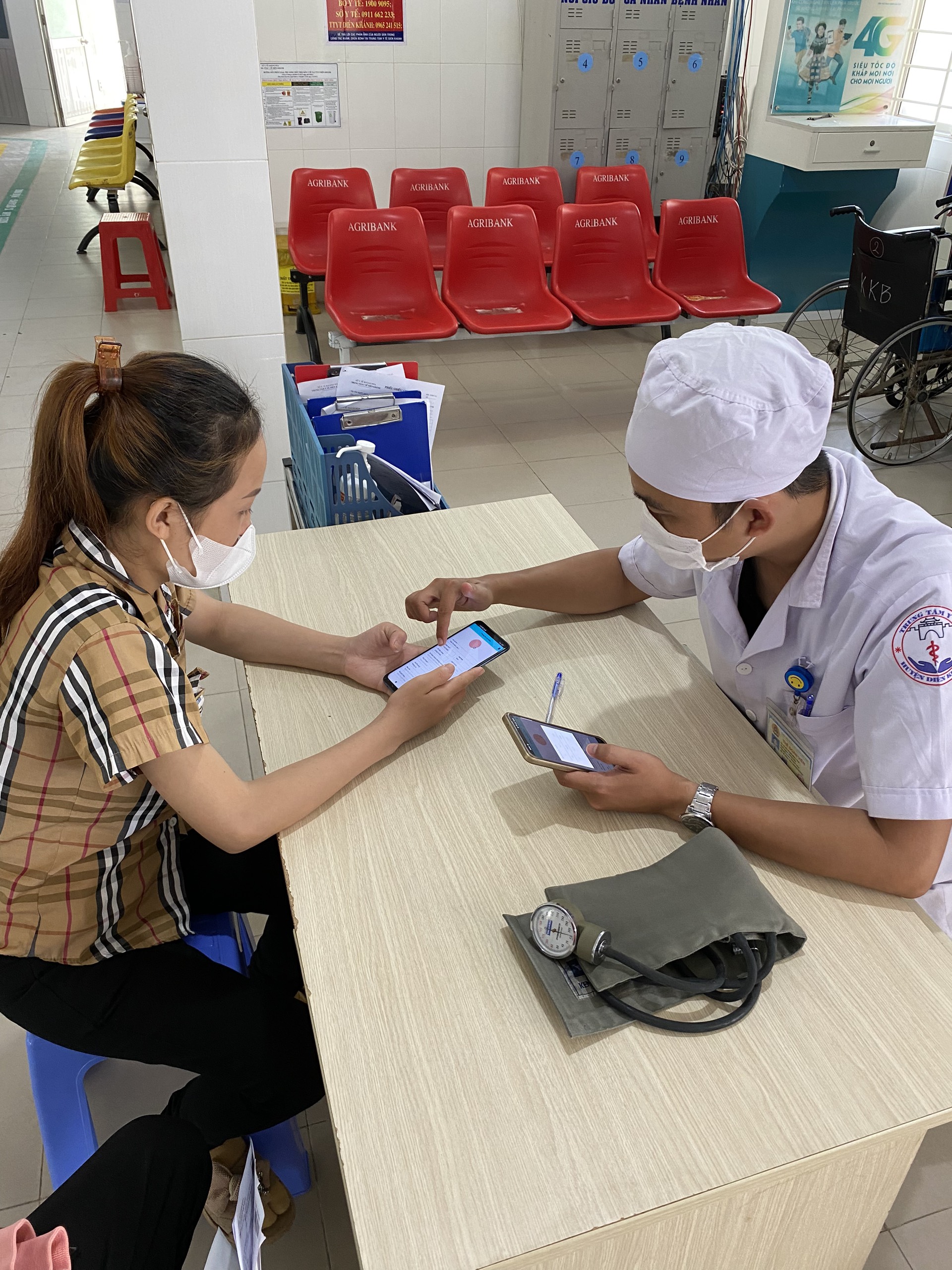 Nhân viên y tế Bệnh viện Đa khoa Diên Khánh hướng dẫn người dân tải app Ourhealth