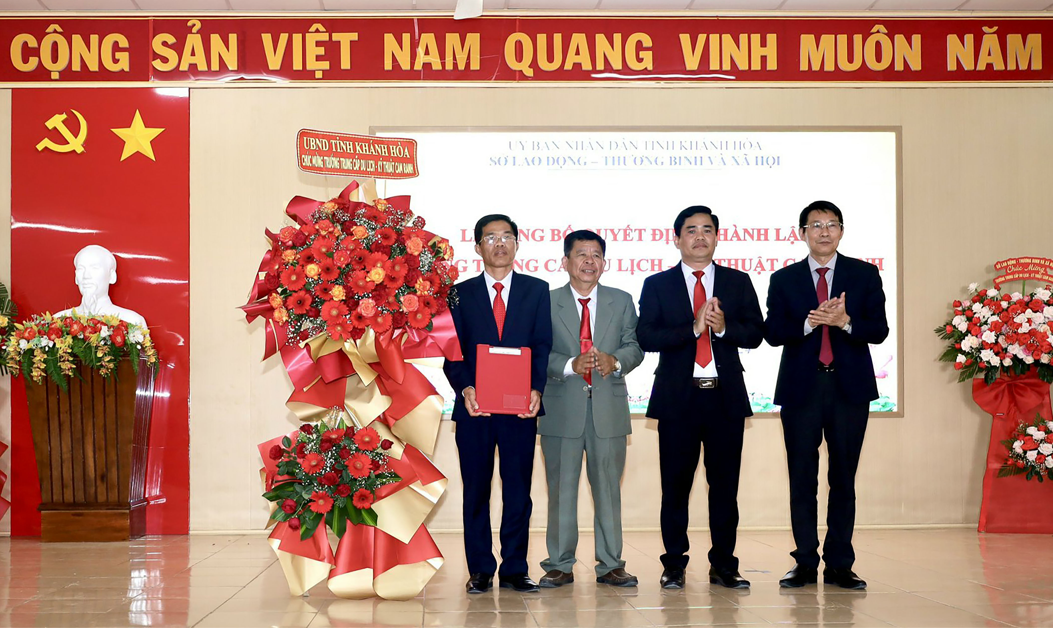 Đồng chí Đinh Văn Thiệu - Phó Chủ tịch UBND tỉnh trao quyết định thành lập Trường Trung cấp Du lịch - Kỹ thuật Cam Ranh cho lãnh đạo nhà trường. Ảnh: Văn Giang.