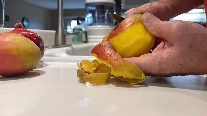 Cần gọt sạch vỏ xoài trước khi ăn để tránh dị ứng. (Ảnh: iStock)