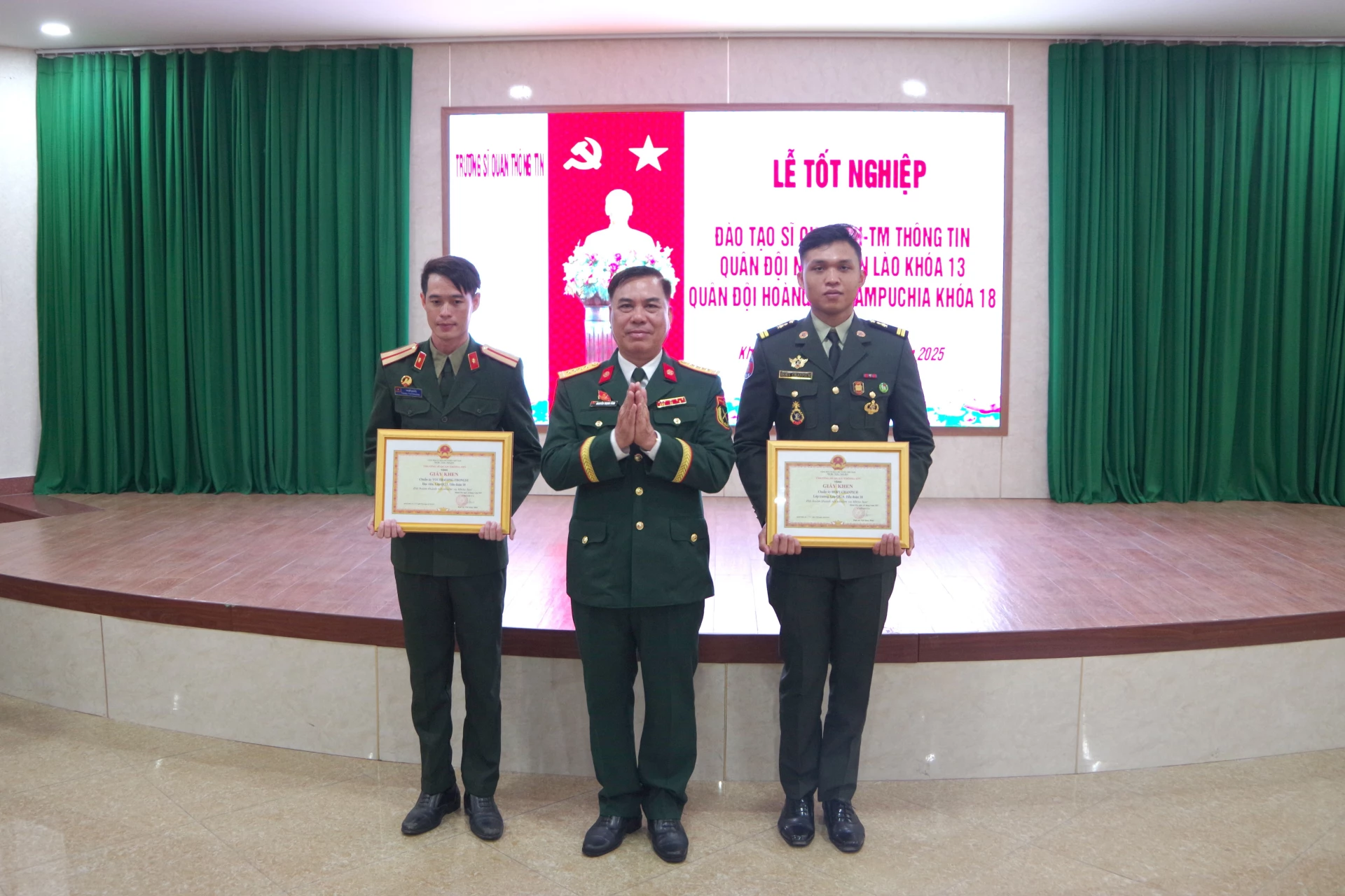 Đại tá Nguyễn Trọng Vĩnh trao giấy khen cho 2 học viên tiêu biểu.