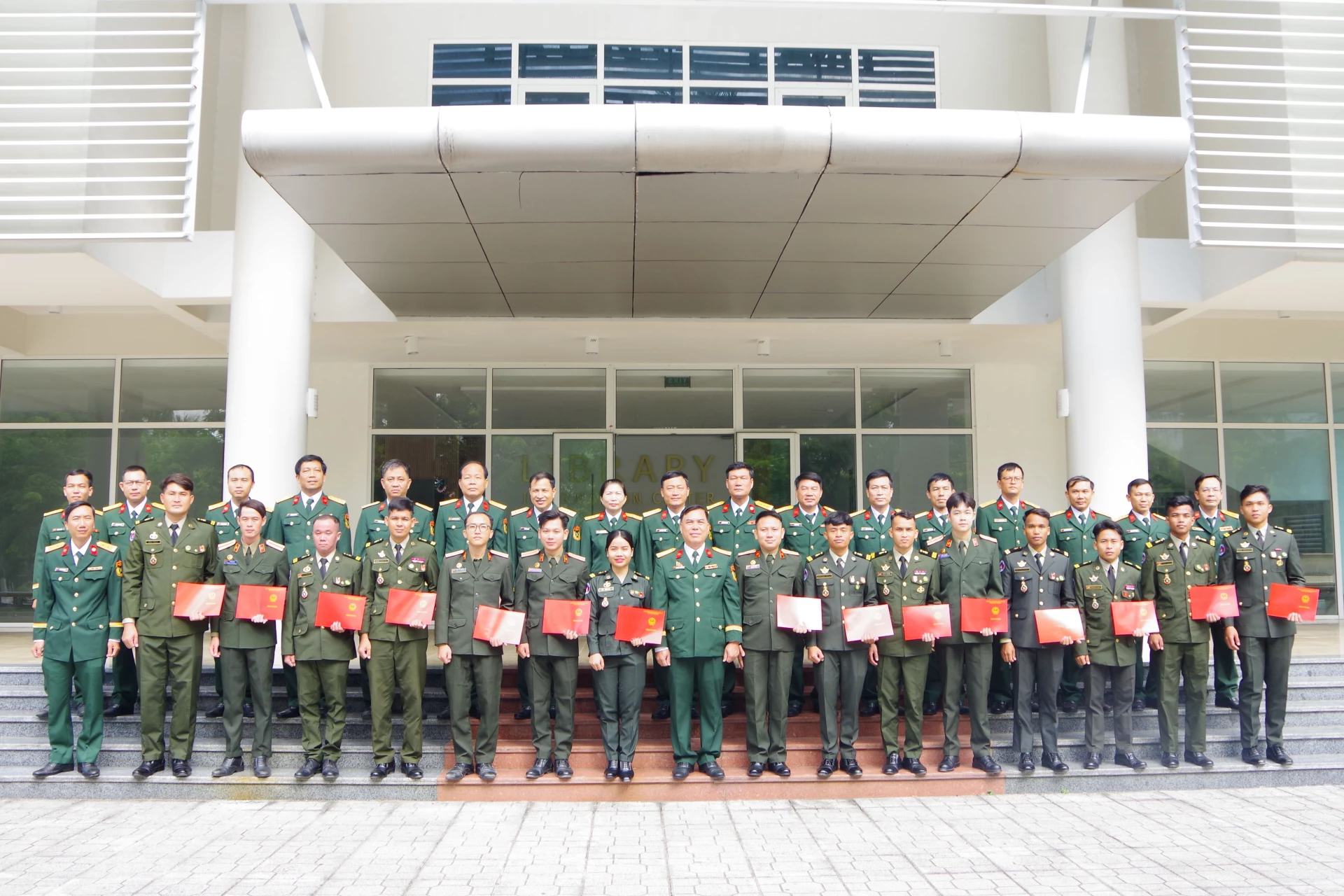 Thủ trưởng nhà trường chụp ảnh lưu niệm với các học viên tốt nghiệp.