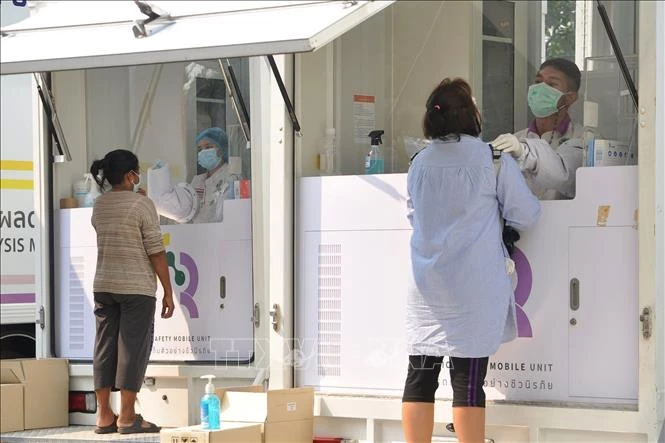 Nhân viên y tế lấy mẫu xét nghiệm COVID-19 cho người dân tại Bangkok, Thái Lan. Ảnh: THX/TTXVN