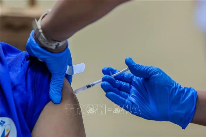 Nhân viên y tế tiêm vaccine phòng COVID-19 cho người dân. Ảnh: THX/TTXVN