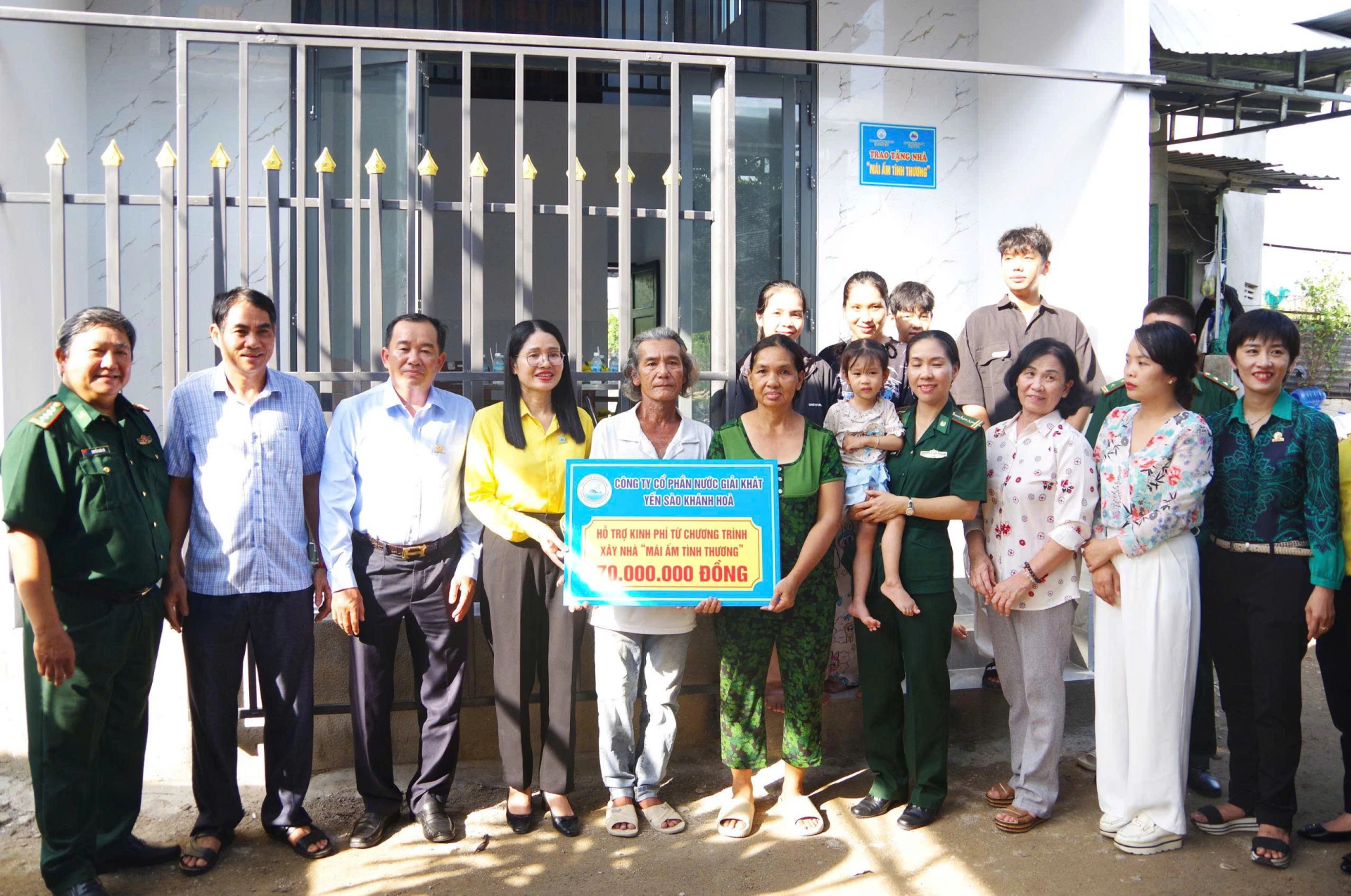 Ảnh 01: Công ty Cổ phần Nước giải khát Yến Sào Khánh Hòa trao bảng tượng trưng cho gia đình bà Võ Thị Bảy.