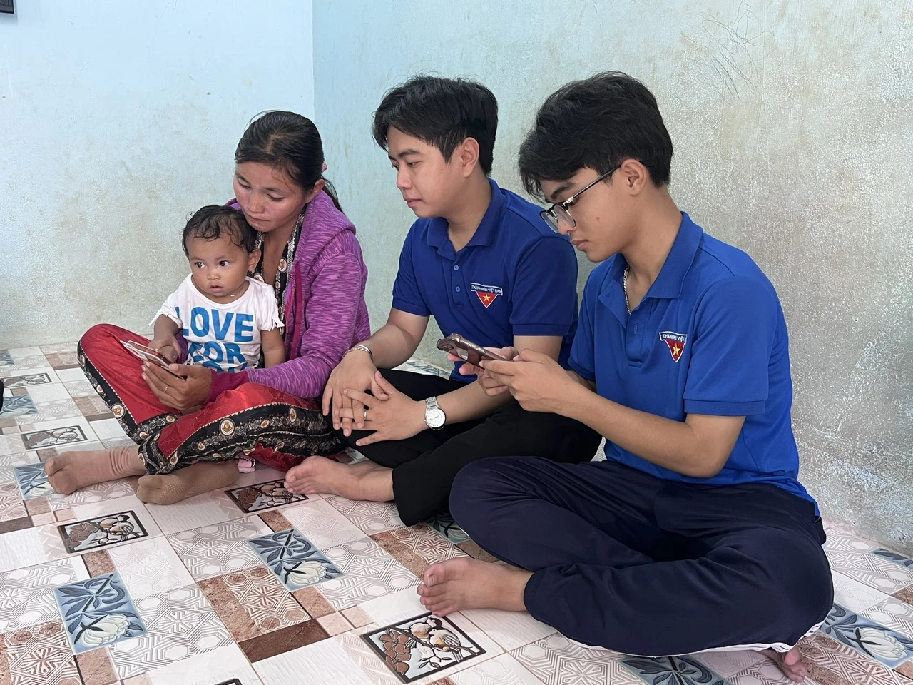 Các bạn đoàn viên hướng dẫn hộ dân thôn Suối Lau 3 xem bài viết chống tảo hôn, hôn nhân cận huyết trên mạng xã hội