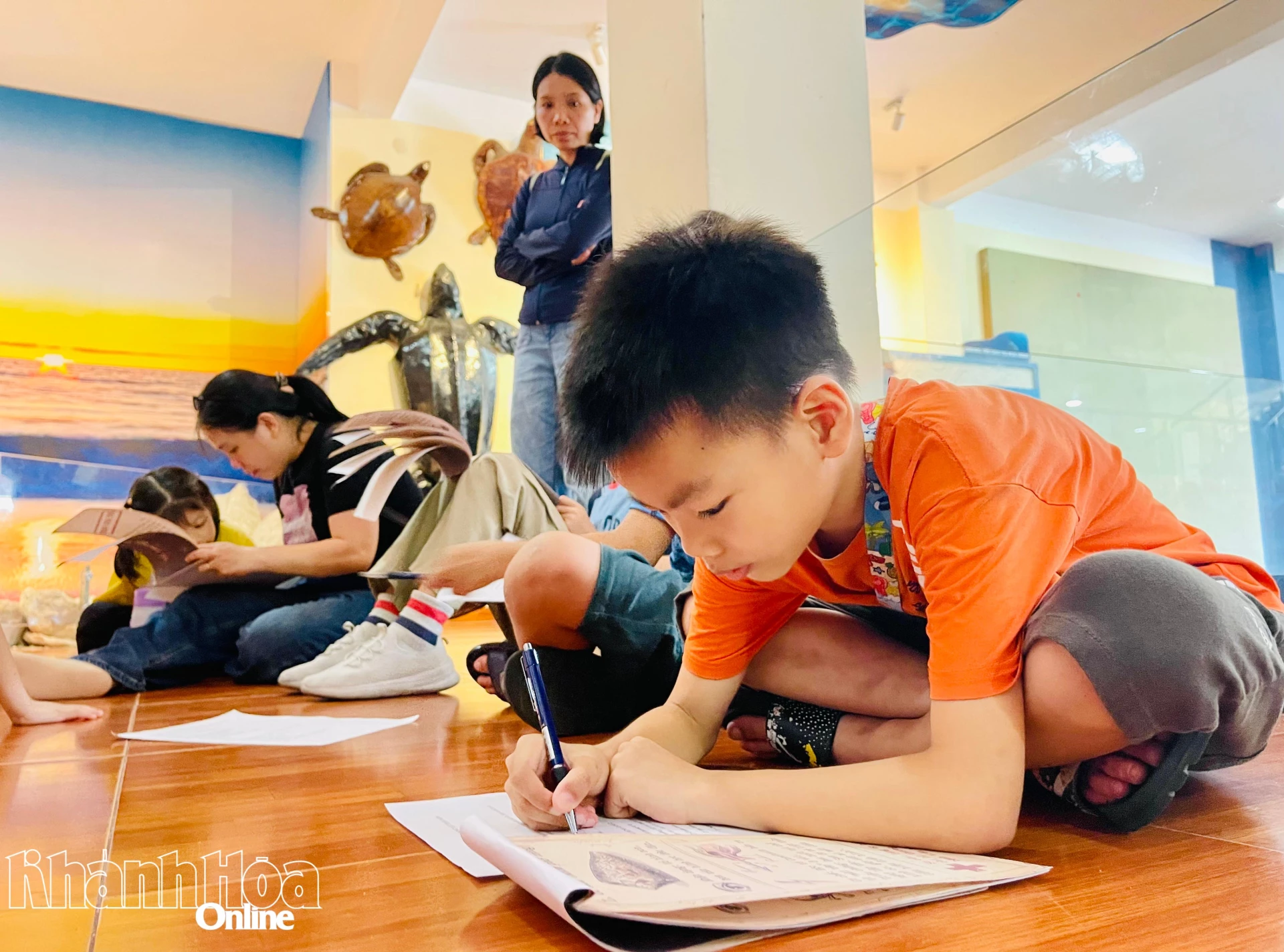 Một bạn nhỏ say sưa đọc tài liệu và trả lời các câu hỏi khi thử tài làm Bác sĩ đại dương.