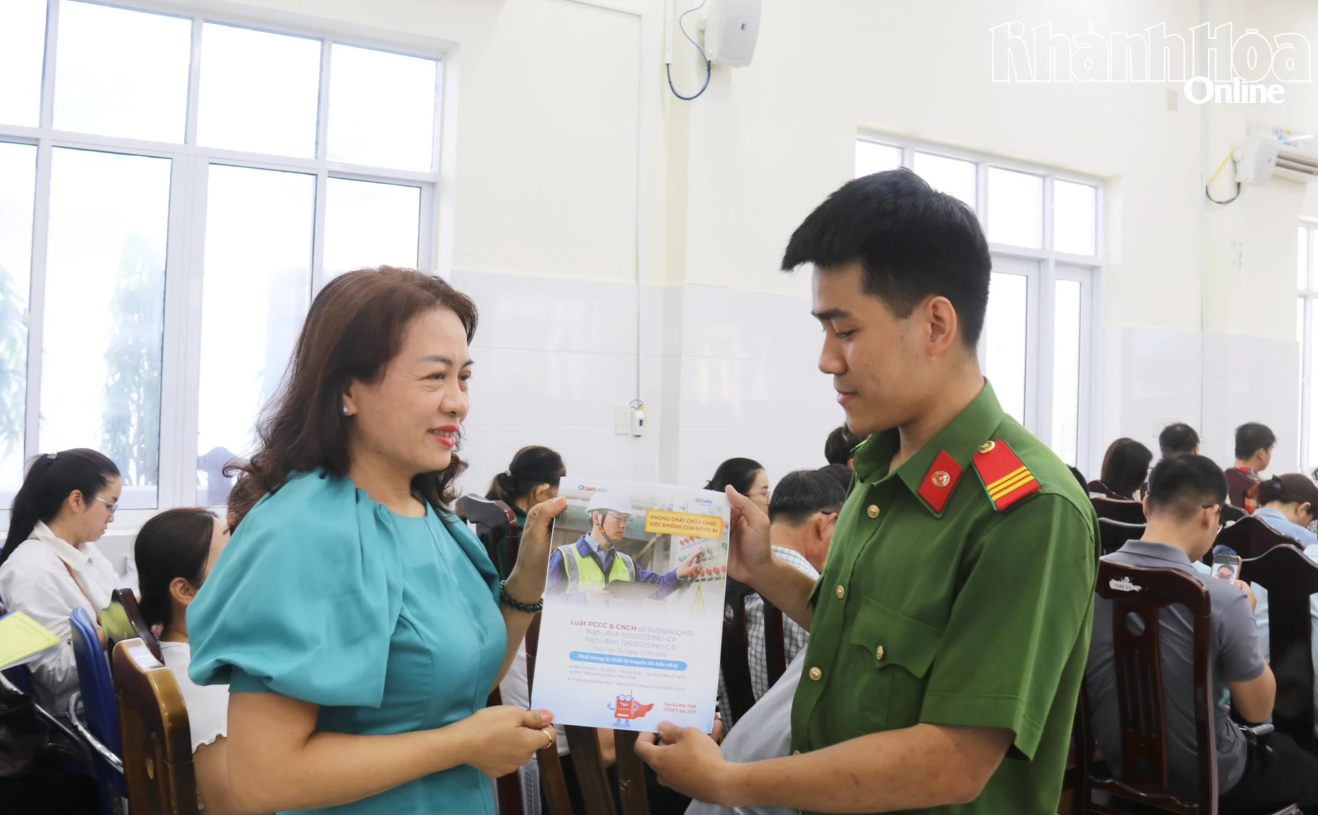 Công an phường Nam Nha Trang phát tờ rơi hướng dẫn kết nối thiết bị truyền tin báo cháy cho các đại biểu.