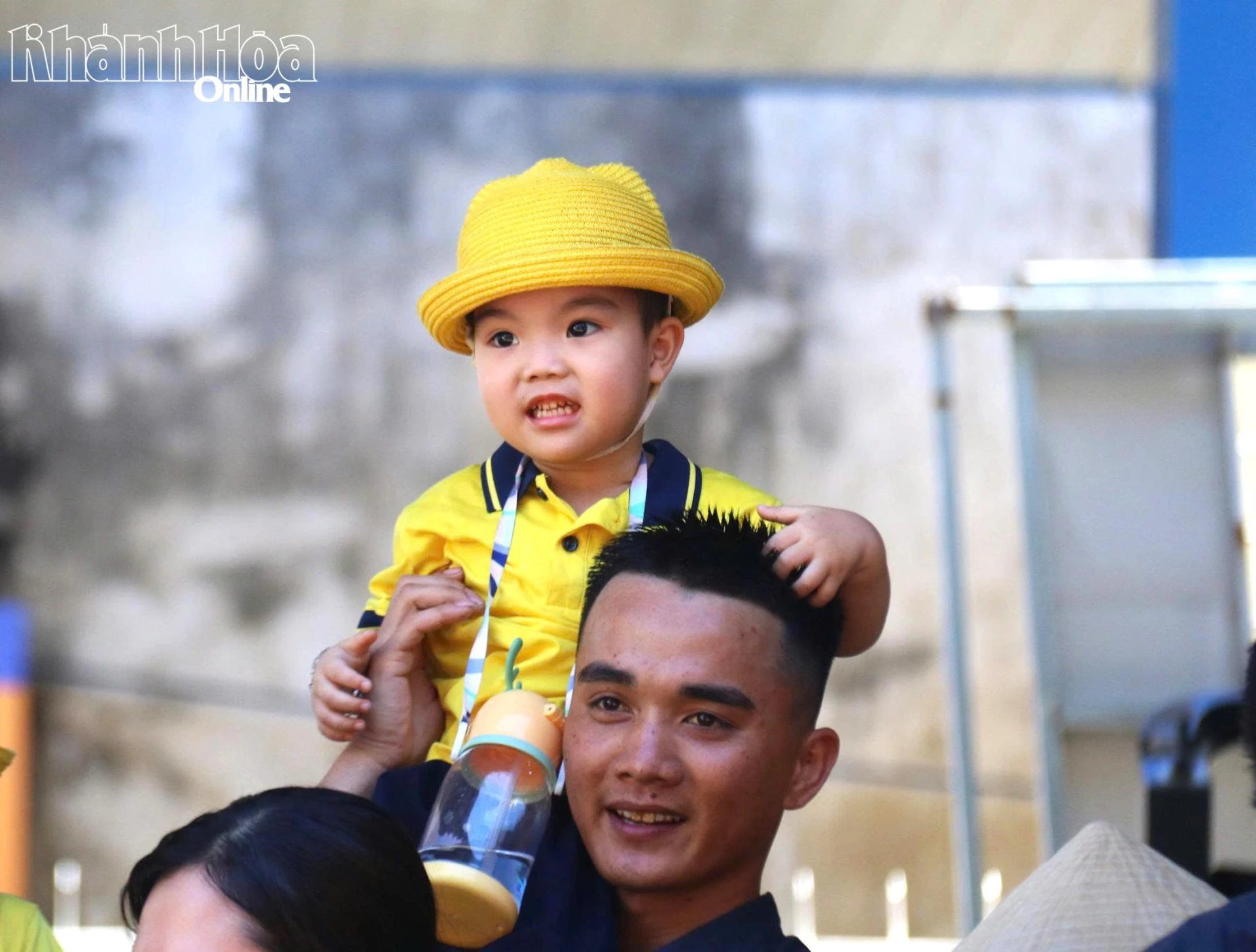 Một chiến sĩ nhí được chiến sĩ cảnh sát chữa cháy công kênh trên vai.