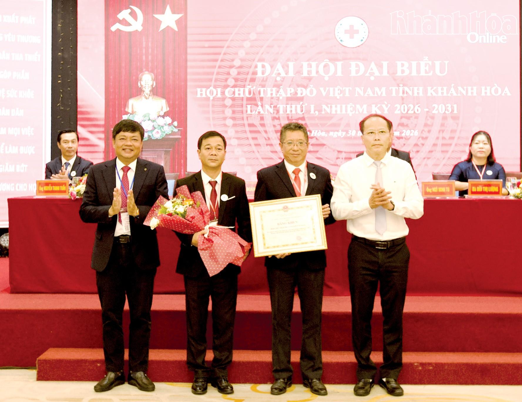 Đồng chí Nguyễn Khắc Hà trao bằng khen của UBND tỉnh cho Hội Chữ thập đỏ tỉnh.