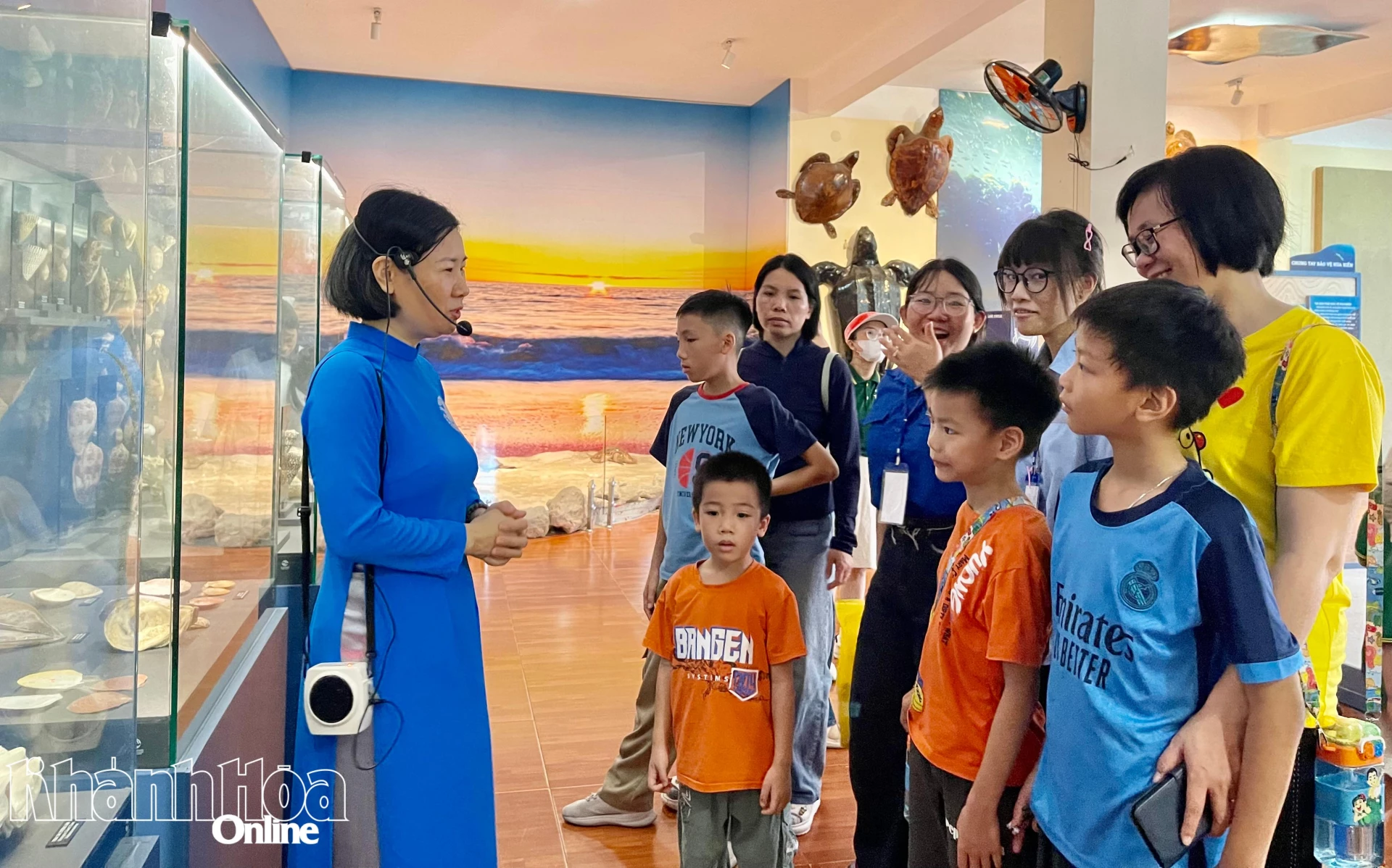 Phụ huynh và các bạn nhỏ chăm chú lắng nghe thuyết minh về sinh vật thân mềm.
