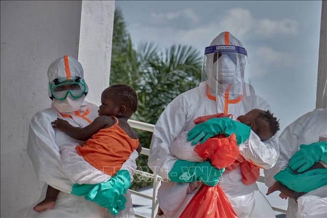 Nhân viên y tế ôm các bệnh nhi tại trung tâm điều trị Ebola ở Bunia, CHDC Congo. Ảnh: THX/TTXVN


