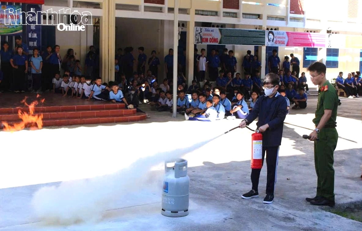 Các em thực hành kỹ năng dập lửa bằng bình chữa cháy xách tay.
