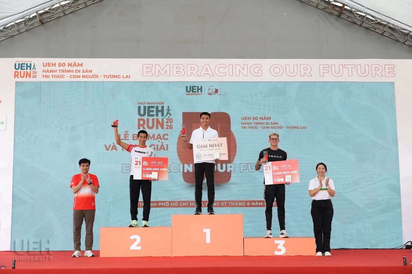 PGS.TS. Bùi Quang Hùng - Giám đốc UEH cùng Bà Phạm Thị Minh Thy - Giám đốc Phòng Giao dịch Phạm Ngọc Thạch, Ngân hàng TMCP Phương Đông (OCB) trao giải cho Top 3 Nam cự ly 21km.
