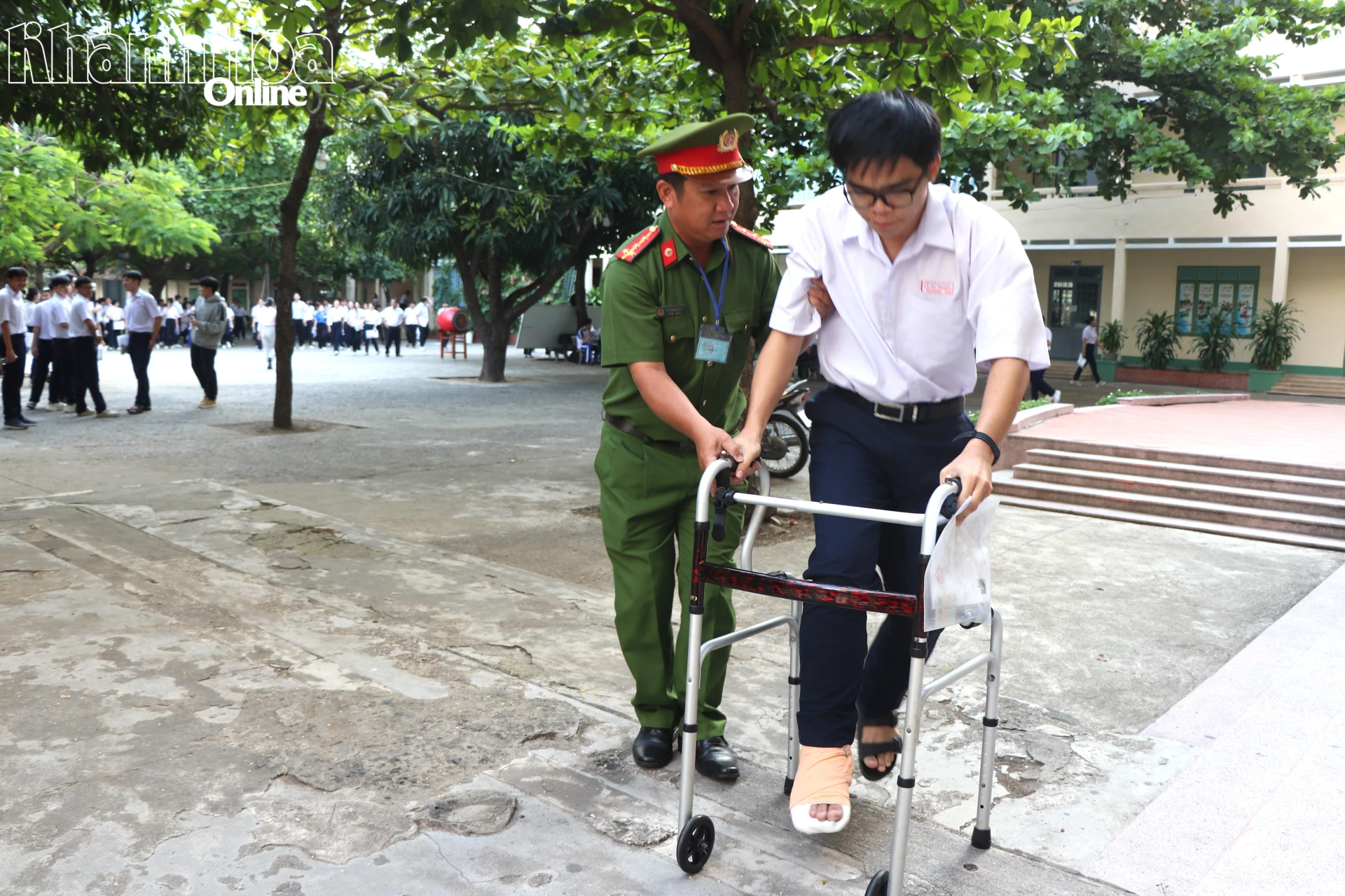 Thí sinh Nguyễn Đức Hoàng, học sinh Trường THPT Lý Tự Trọng bị gãy chân được cán bộ công an hỗ trợ đưa vào phòng thi tại điểm thi Trường THPT Nguyễn Thiện Thuật (phường Nha Trang).