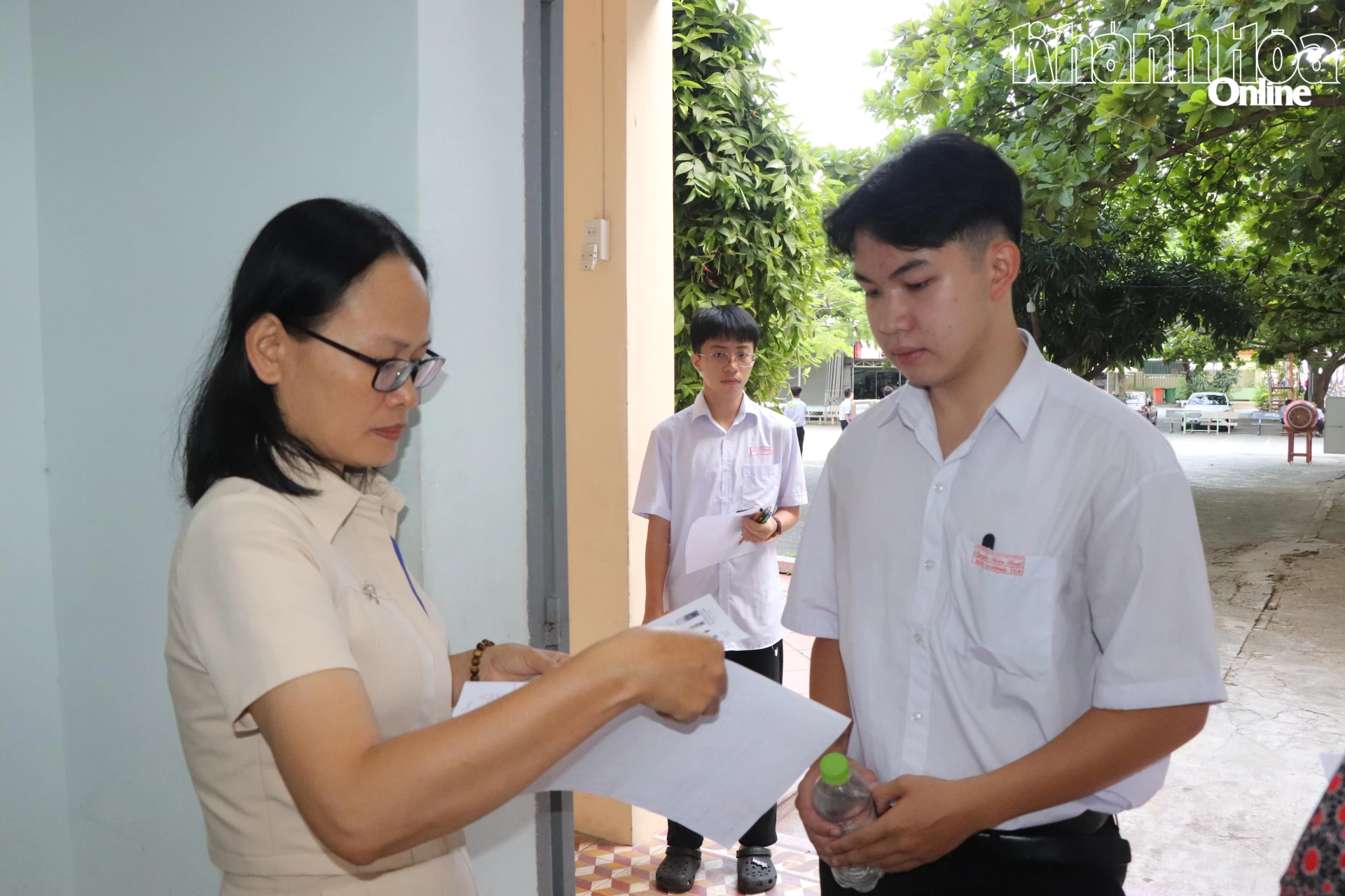Giám thị đối chiếu thông tin cá nhân của thí sinh trước khi vào phòng thi.