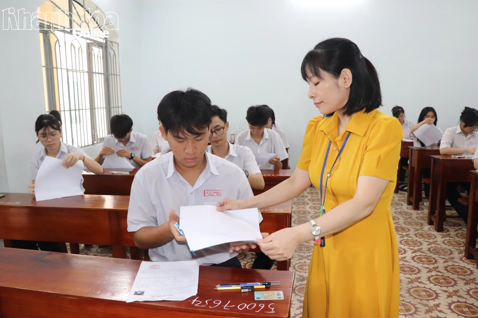 Phát giấy thi cho thí sinh.