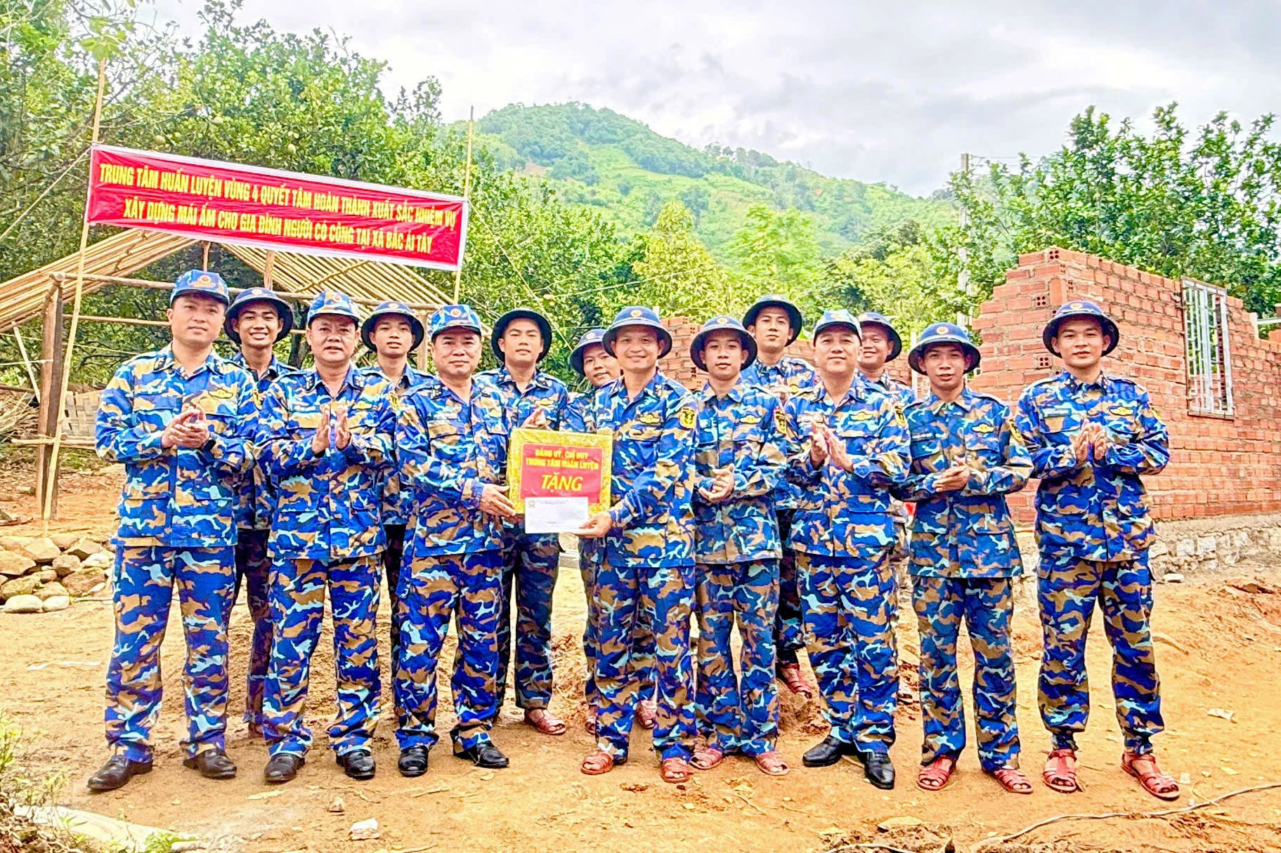 Thượng tá Nguyễn Đình Mão tặng quà động viên lực lượng tham gia xây nhà.