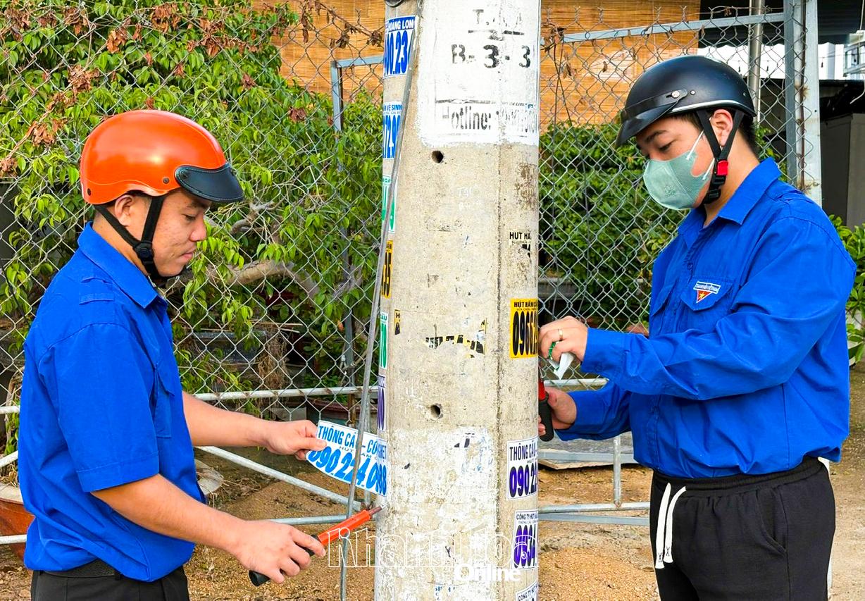 Thanh niên phường Cam Ranh ra quân tẩy xóa quảng cáo sai quy định.