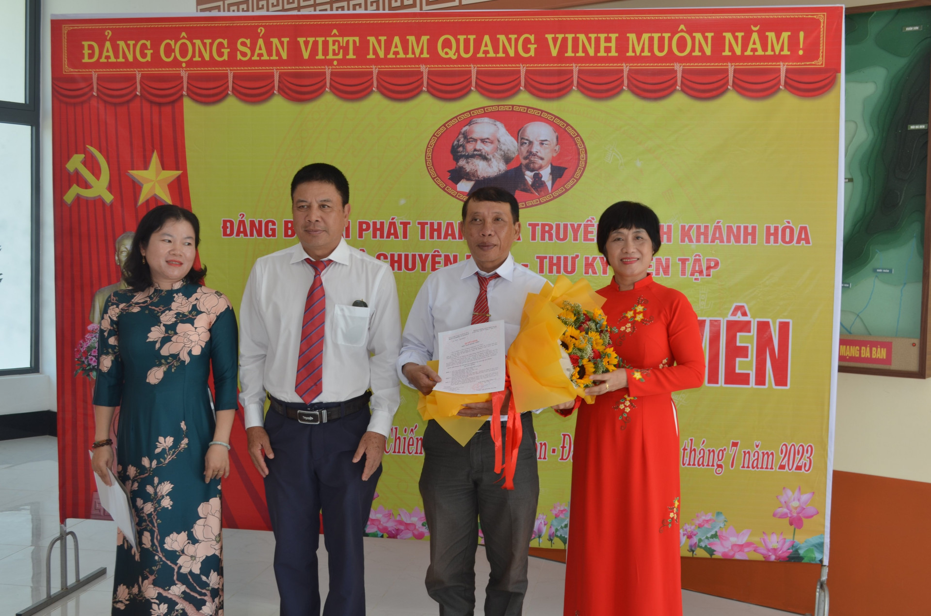  bà Phạm Thị Khánh Hương - Bí thư Đảng ủy Khối các cơ quan tỉnh và ông Lê Anh Vũ, Bí thư Đảng bộ, Giám đốc Đài Phát thanh và Truyền hình Khánh Hòa trao quyết định và hoa cho đảng viên mới