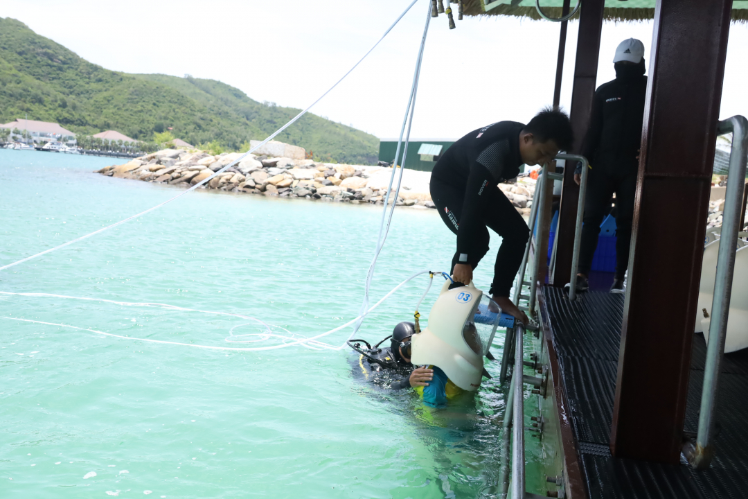 Lowering seawalker helmet on participant’s shoulders

