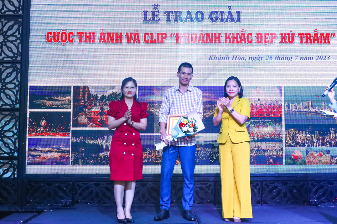 Thai Thi Le Hang, Editor-in-Chief, Secretary of Khanh Hoa Provincial Party Committee, and Luu Hong Van, Deputy Head of the Provincial Department of Propaganda and Training, present first prize in photo category to Vuong Manh Cuong

