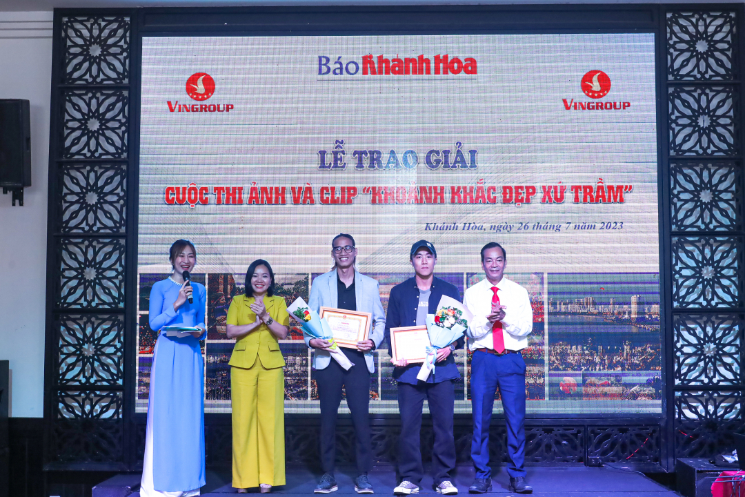 Nguyen Van Thien, Director of Khanh Hoa Provincial Department of Culture and Sports, and Thai Thi Le Hang awarding second prizes in video category to entrants

