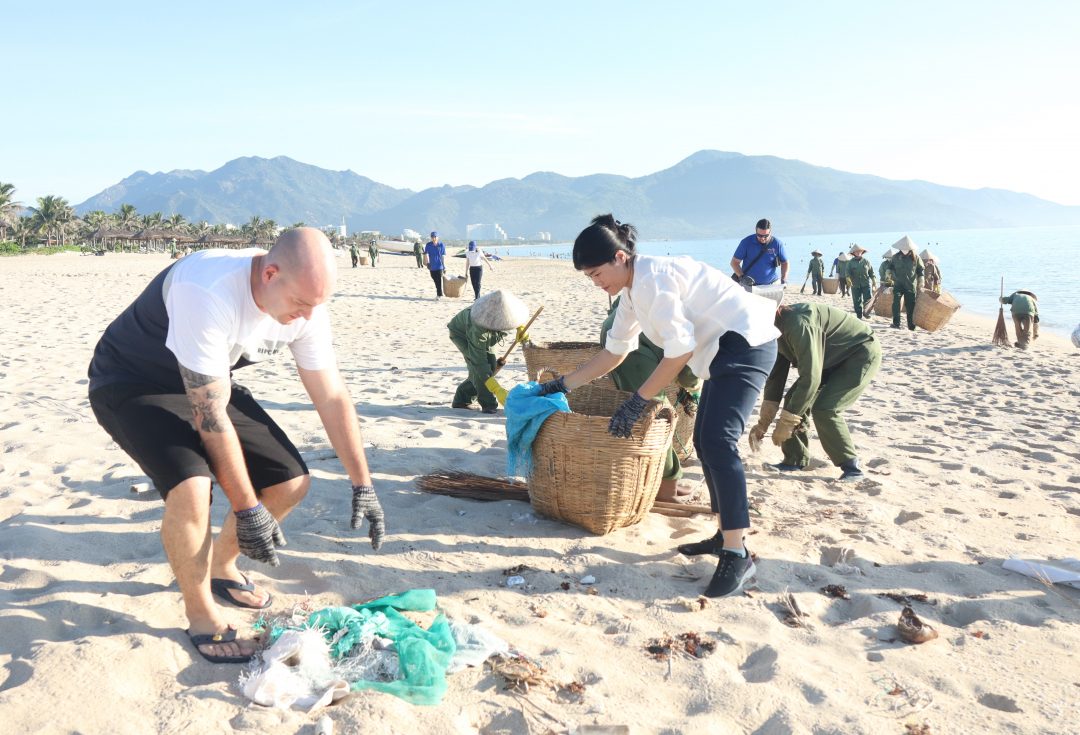 Management and staff of Alma Resort pick up trash on the beach