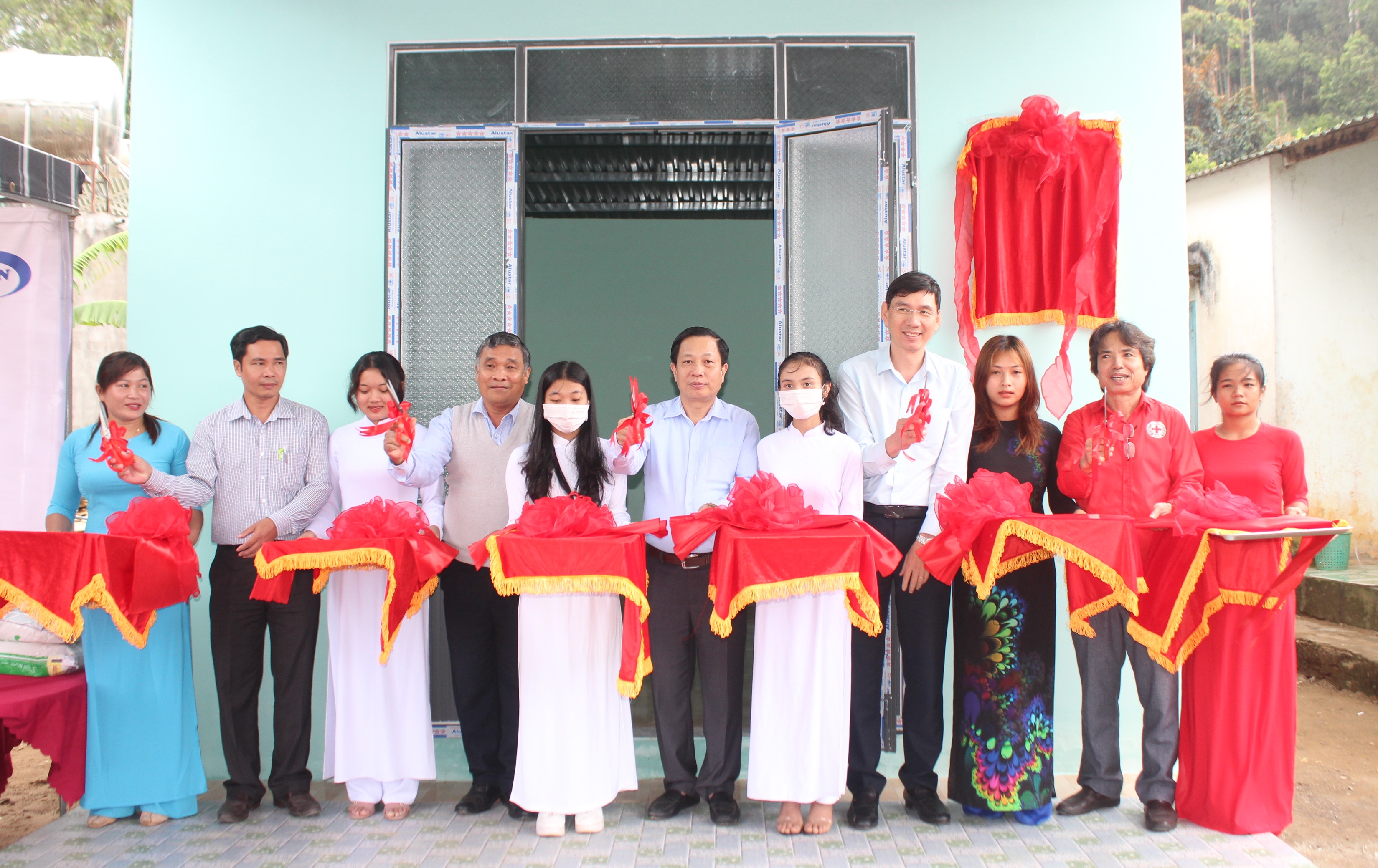 Đồng chí Hà Quốc Trị - Phó Bí thư Tỉnh ủy, Trưởng đoàn đại biểu Quốc hội tỉnh và các đại biểu cắt băng bàn giao nhà cho hộ nghèo huyện Khánh Sơn. Ảnh: VĂN GIANG