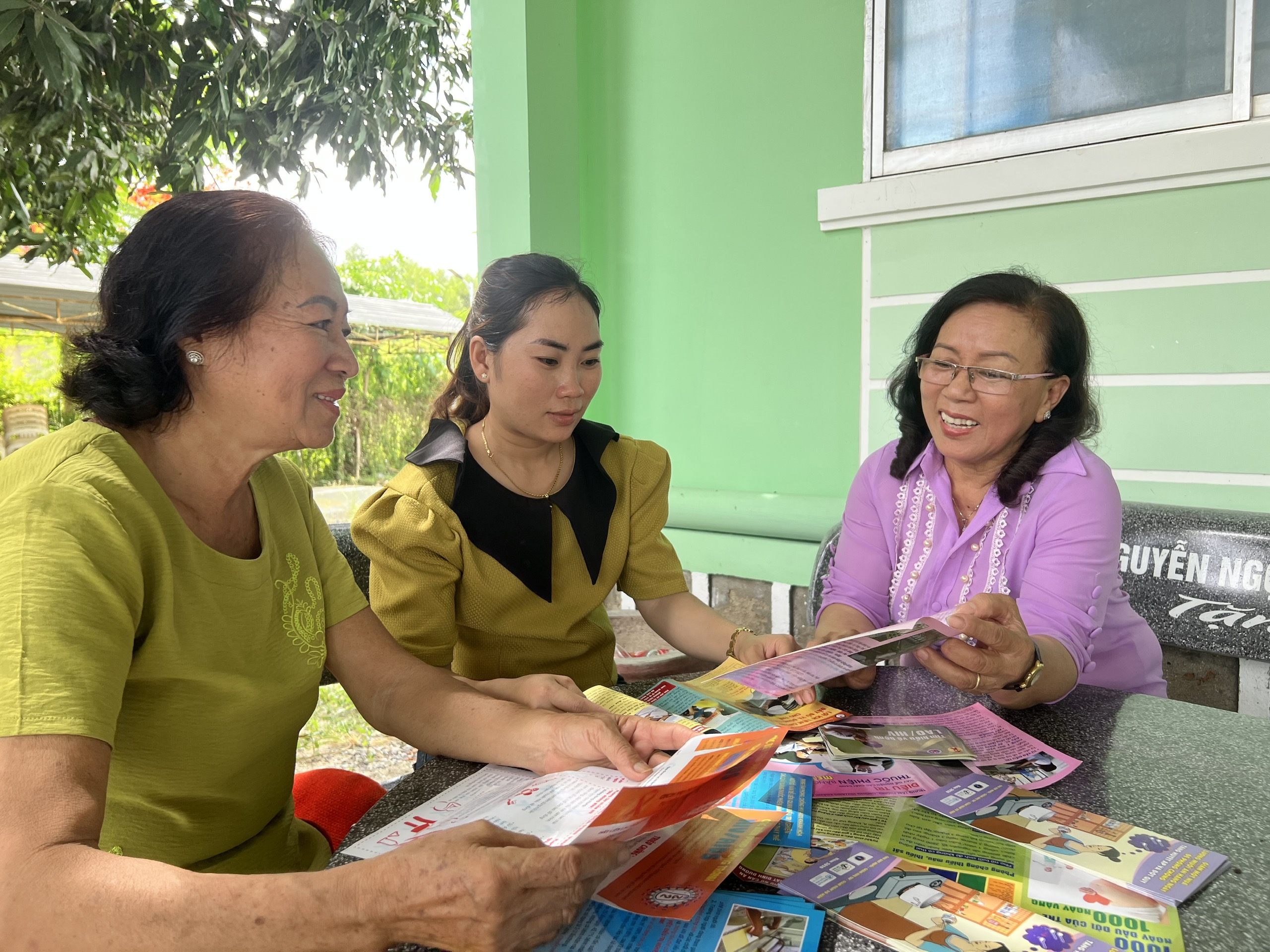 Chị Nguyễn Thị Kim Thoa phát  tờ  rơi, hướng  dẫn  người  dân  cách  phòng và  chăm  sóc bệnh  