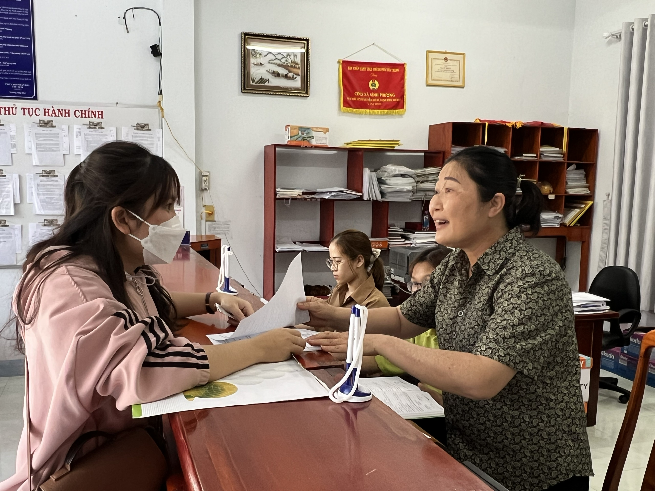 Công chức bộ phận một cửa UBND xã Vĩnh Phương hướng dẫn thủ tục cho người dân.