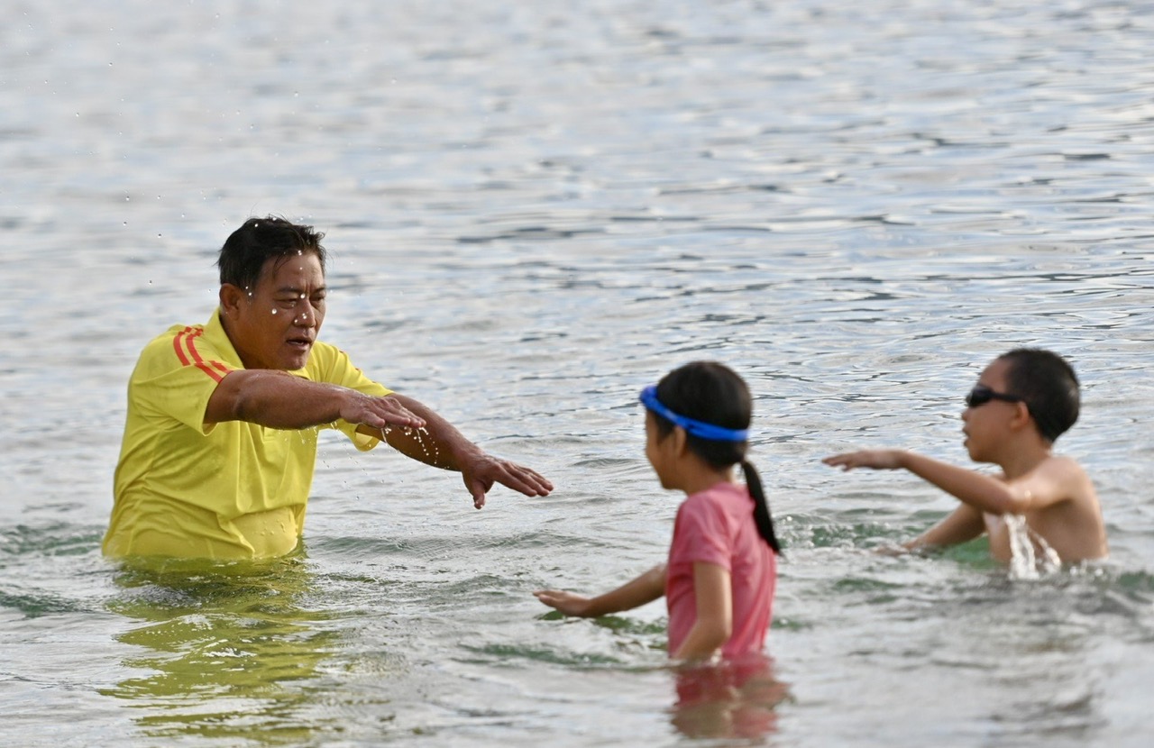 Vinh Anh, a swimming instructor of Nha Trang City Center of Culture, Information and Sports, teaching children how to swim

