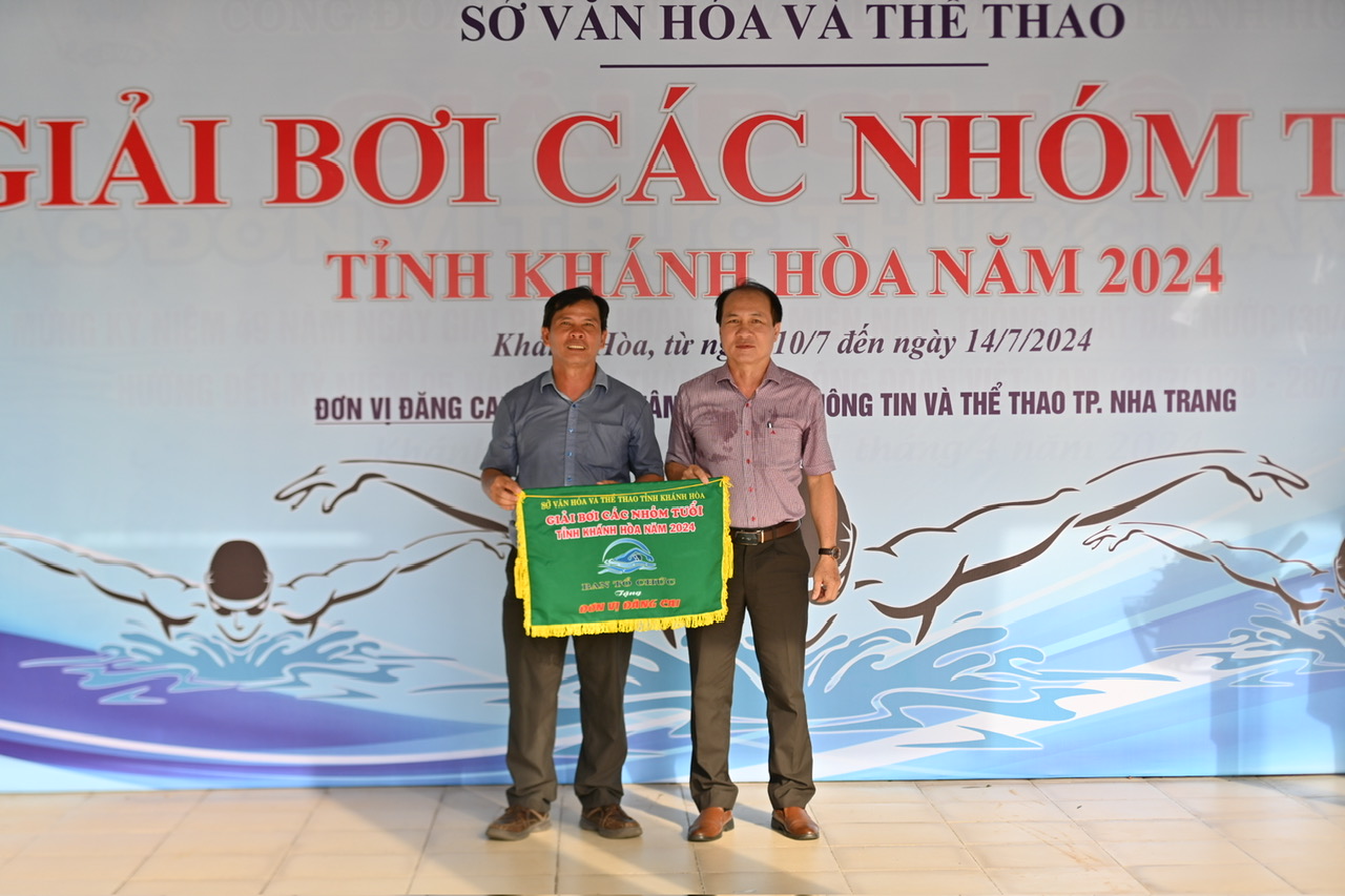 Nguyen Tuan Thanh, Deputy Director of Khanh Hoa Provincial Department of Culture and Sports, head of the organization committee (right) giving flag to the host unit, Nha Trang City

