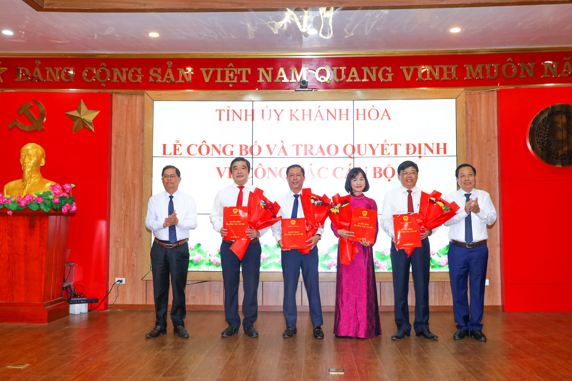 Đồng chí Nguyễn Tấn Tuân và đồng chí Hà Quốc Trị trao quyết định, tặng hoa chúc mừng 4 cán bộ mới được điều động nhận công tác ở các địa phương, đơn vị.