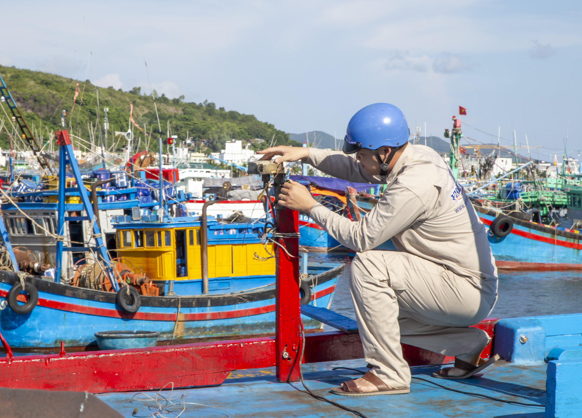 Kỹ thuật viên của Đài Thông tin duyên hải Nha Trang chỉnh sửa và kẹp chì đối với ăng ten thu phát sóng thiết bị giám sát hành trình trên tàu cá.