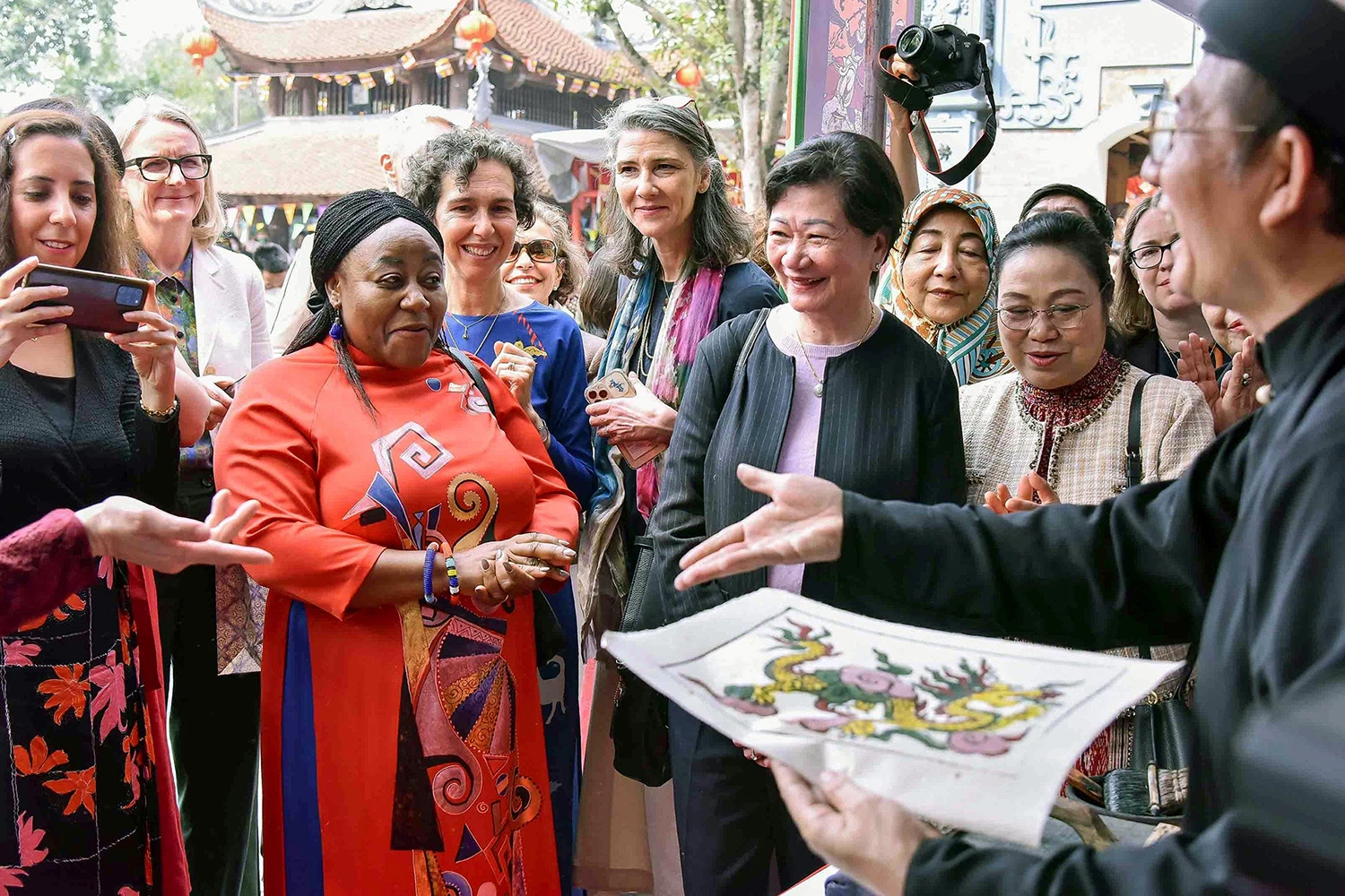 Nghệ nhân giới thiệu về tranh dân gian Đông Hồ cho các nữ đại sứ, trưởng đại diện tổ chức quốc tế tại Việt Nam _Nguồn: vietnamnet.vn

